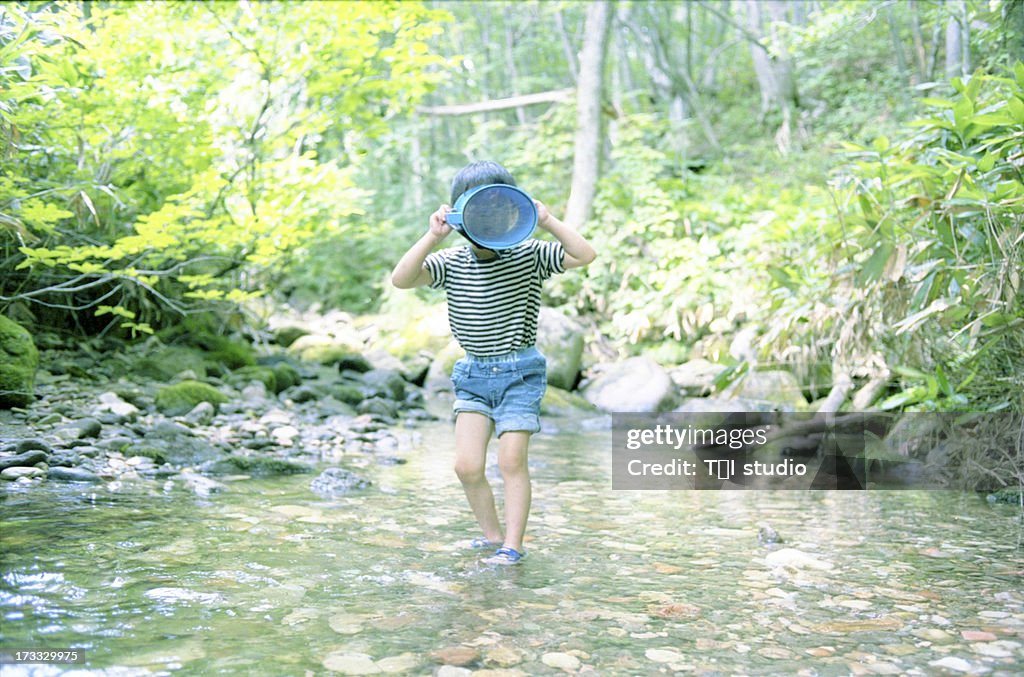 Small Boy Playing In A Stream