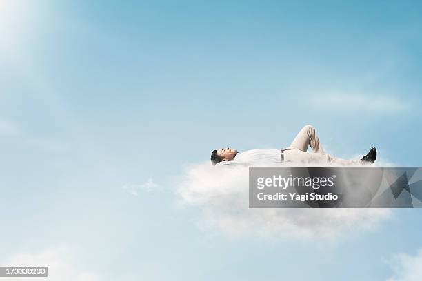 the man is relaxing in the clouds - lying down stockfoto's en -beelden