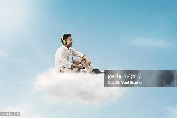 man listening to music above the clouds - 逃げる ストックフォトと画像