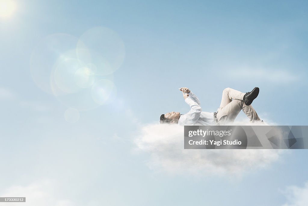 The man is using a smartphone above the clouds