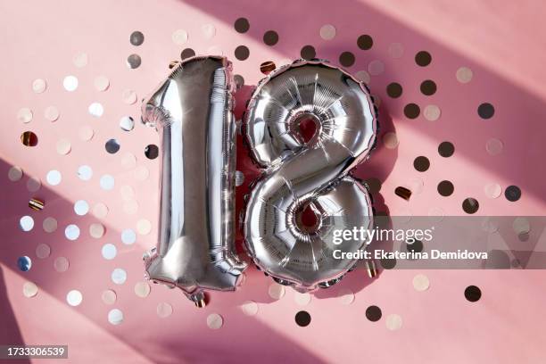 silver numbers 18 eighteen years balloons in sunlight pink background - number 18 stock pictures, royalty-free photos & images