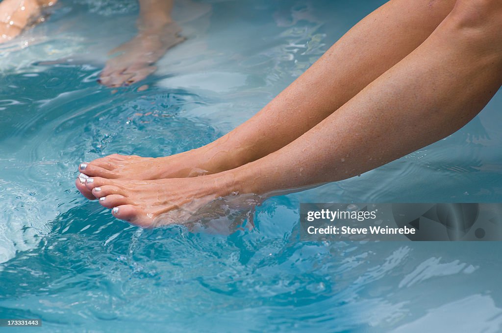 Feet splashing in pool water