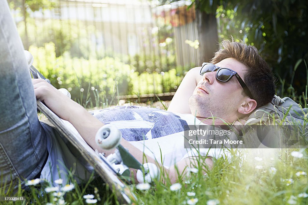 Man relaxing in park with skateboard