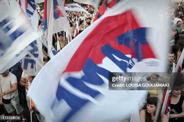 Communist affilited protesters wave flags as they participate in the PAME union rally at Syntagma Square in central Athens on July 11, 2013. Greece's...