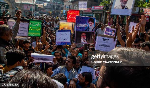 Kashmiri Muslims hold placards as they chant slogans against Israel and the U.S. During a protest against Israel's military operations in Gaza, on...