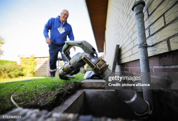 October 2023, Schleswig-Holstein, Bad Brahmstedt: An employee of a diesel and heating oil company connects a hose with nozzle to a filler neck for...