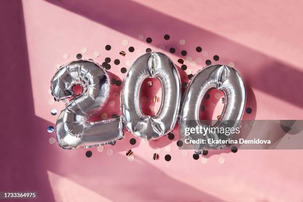 silver numbers 200 two hundred years balloons in sunlight pink background - number 200 stock pictures, royalty-free photos & images