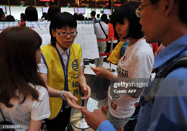 Taipei Main Station employee answers questions for visitors at Taipei's main station as Typhoon Soulik approaches northern Taiwan on July 12, 2013....