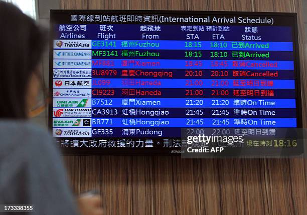 An electronic board showing disruptions to air travel is displayed at Taipei's main station as Typhoon Soulik approaches northern Taiwan on July 12,...