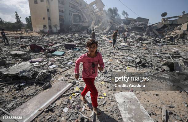 Girl walks amid the rubble of residential buildings after Israeli airstrikes at al-Zahra neighborhood in Gaza Strip on October 19, 2023.