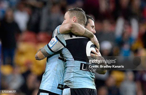 Todd Carney and Michael Gordon of the Sharks celebrate victory after the round 18 NRL match between the Brisbane Broncos and the Cronulla Sharks at...