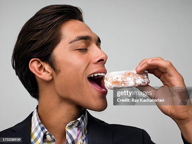 man about to bite a donut - eating donuts foto e immagini stock