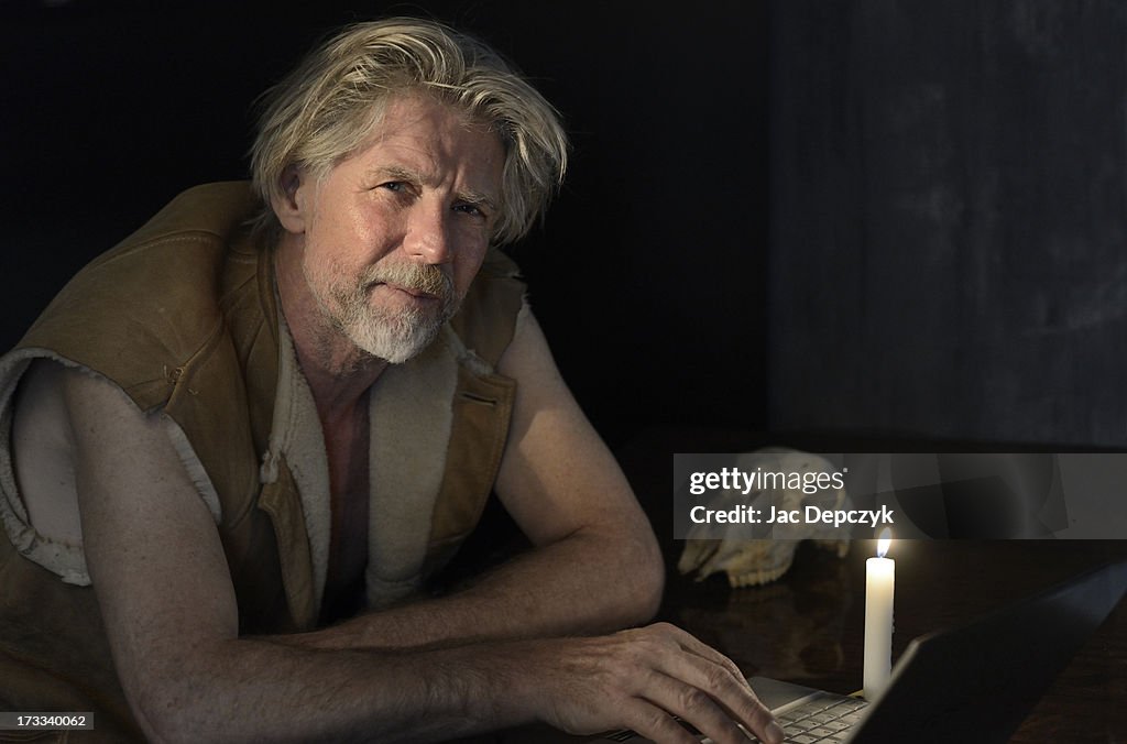Mature man sitting with dead laptop at candlelight