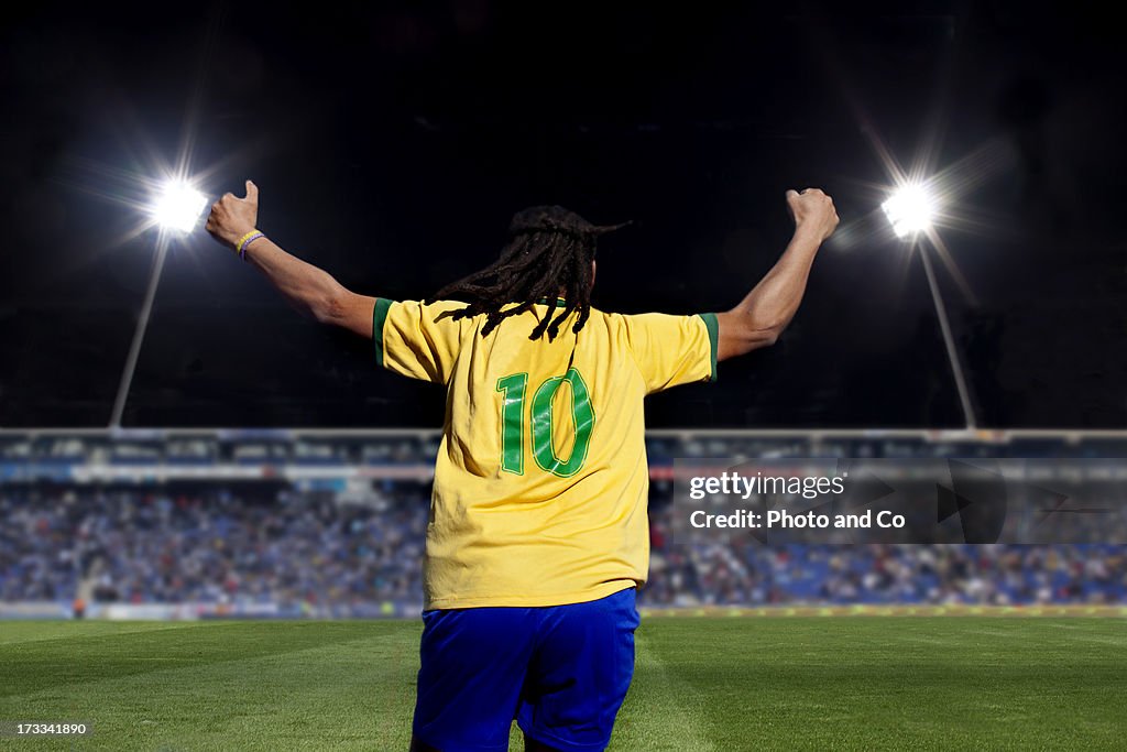 Soccer player exulting in stadium