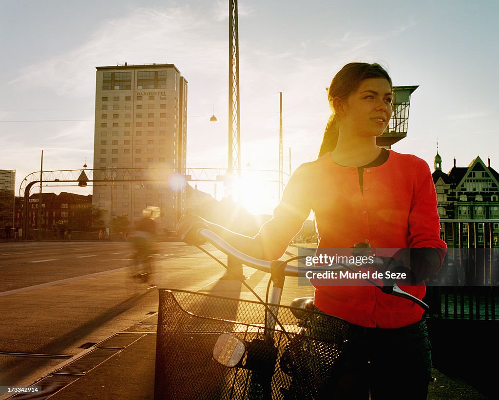 Girl with bicycle by sunset
