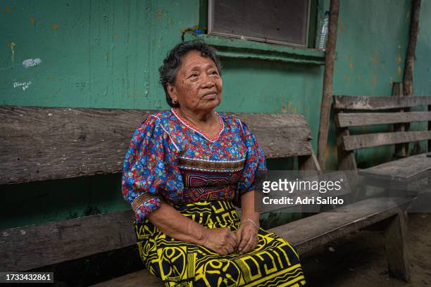 Magdalena sits on a bench wearing traditional Kuna clothes where she owns a small food and drink store on October 11, 2023 in Gardi Sugdub, Panama....