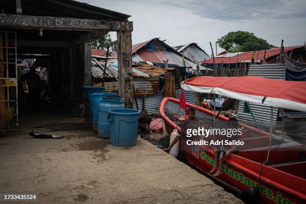 Two children sit on a boat moored to one of the docks on the island on October 11, 2023 in Gardi Sugdub, Panama. Indigenous communities of the small...