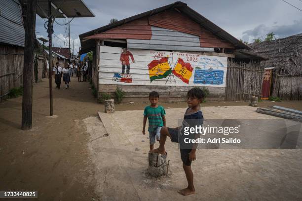 Two boys play in front of one of the community murals on October 11, 2023 in Gardi Sugdub, Panama. Indigenous communities of the small island,...