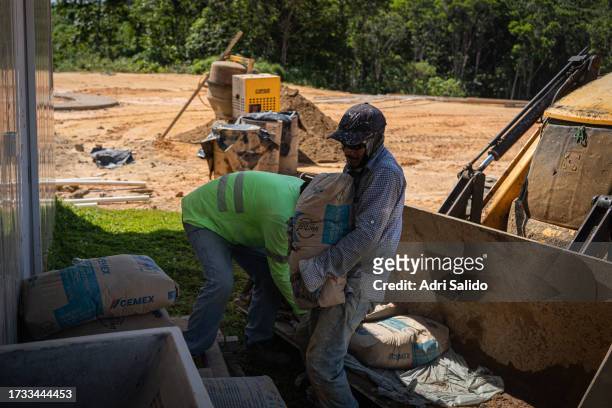 Workers move sand bangs for the construction of one of the houses in the new community on October 12, 2023 in Kuna Yala, Panama. Indigenous...