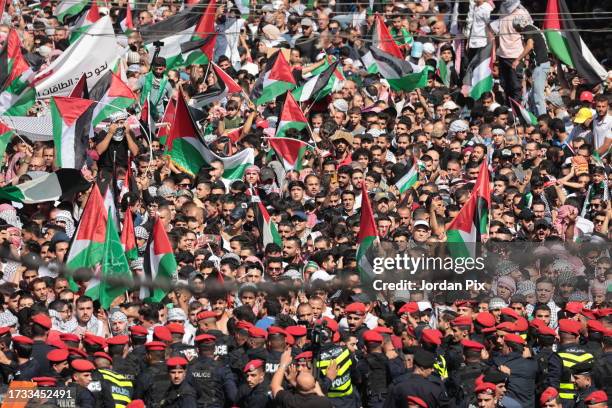 Jordanian protesters march at the downtown in front of the Husseini Mosque, raising the Jordanian and Palestinian flags, demanding an end to the...