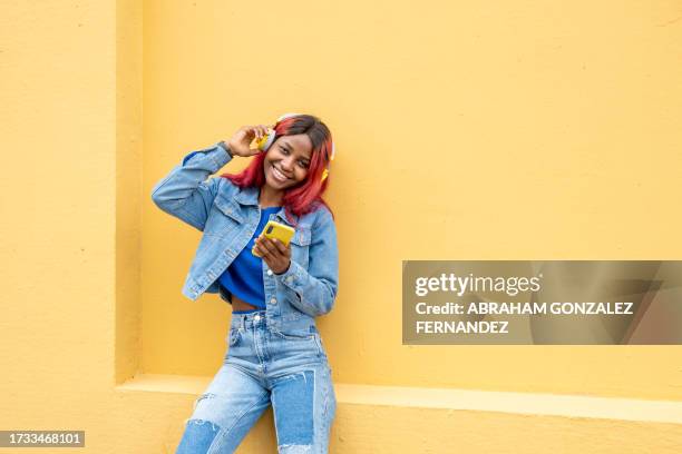 cool adolescent afro-américain écoutant de la musique - fashion pretty woman listening music in headphones with smartphone colorful photos et images de collection
