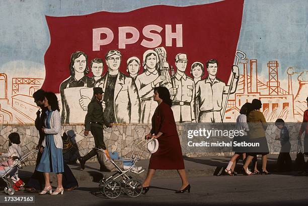 Albanie Korcia at the end of the communist regime. Pedestrians pass by a Realistic socialist style painting, with a slogan; glory to the communist...