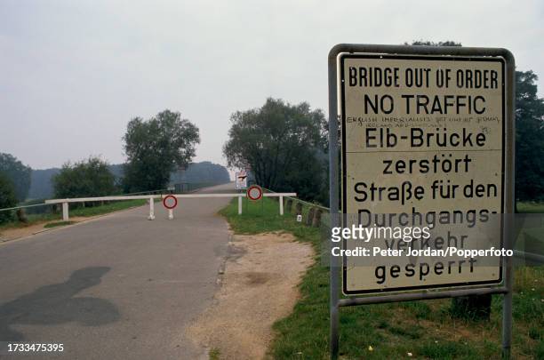 Road sign warns that the bridge ahead is 'Out Of Order' at a former crossing of the River Elbe at the border, known as the Iron Curtain, between West...
