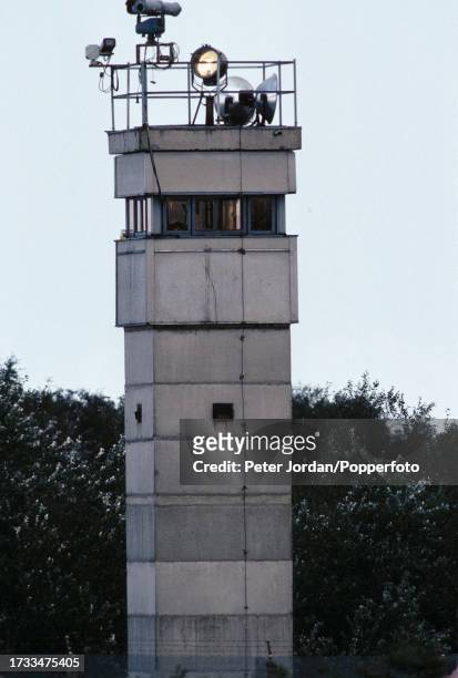 An East German observation tower with camera surveillance equipment on top stands on the border, known as the Iron Curtain, between West and East...