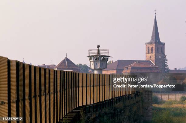 An East German observation tower rises above the security fence beside the River Werra at the border, known as the Iron Curtain, between West and...