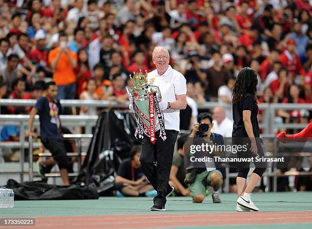 Look-a-like of Sir Alex Ferguson Carries the English Premier League trophy during a Manchester United training session at Rajamangala Stadium on July...