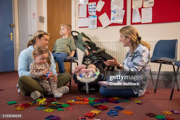 childcare meeting in community centre - baby two baby stock pictures, royalty-free photos & images