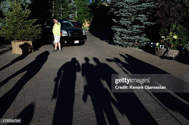 News reporters and photographers wait outside the Sun Valley Inn during the Allen & Co. Annual conference as a security officer watches July 12, 2013...