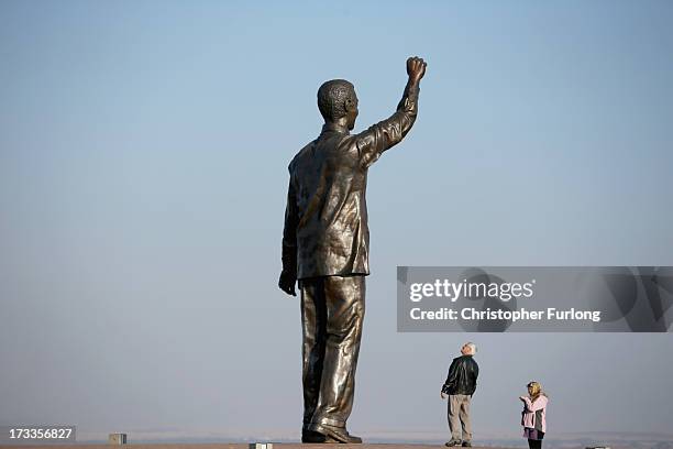 Visitors view a statue of Nelson Mandela which overlooks the city of Bloemfontein, the birthplace of the ANC, on July 12, 2013 in Bloemfontein, South...