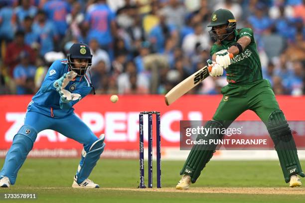 Bangladesh's Mahmudullah plays a shot as India's KL Rahul watches during the 2023 ICC Men's Cricket World Cup one-day international match between...