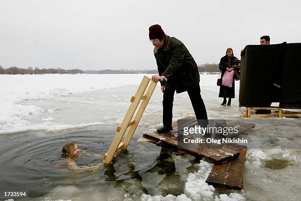 Russian girl submerges himself in the cold water during a ceremony for the Orthodox Epiphany, on the banks of the Moscow River January 19, 2003 in...