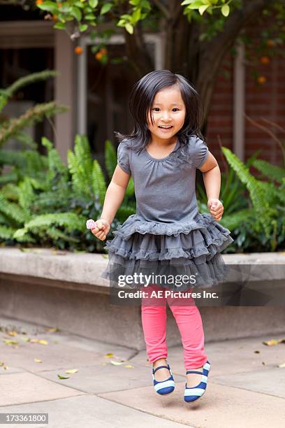 child in frilly dress jumping - froncé photos et images de collection