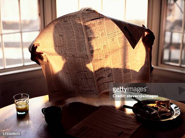 breakfast reading morning paper - newspaper stockfoto's en -beelden