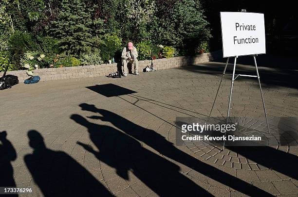 Shadows of news photographers are cast as they wait outside the Sun Valley Inn for the arrivals of media and tech moguls for Allen & Co.'s annual...