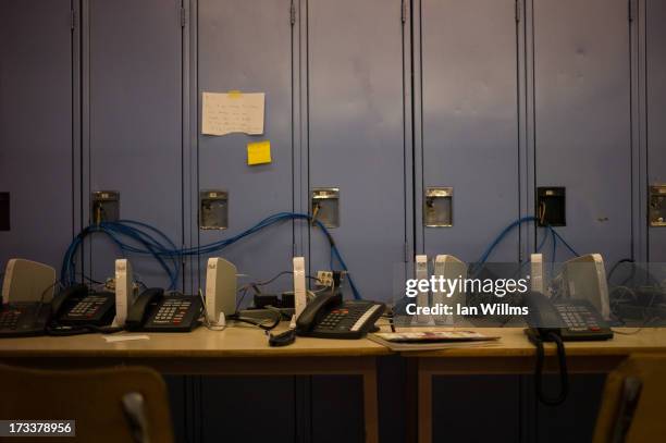 Communal phone lines for displaced local residents are shown at a Red Cross disaster relief centre set up at a secondary school July 12, 2013 in...