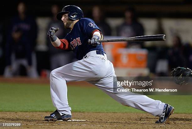 Dutin Pedroia of the Boston Red Sox hits a two-run single, scoring Jose Iglesia and Shane Victorino in the eighth inning against the Oakland...