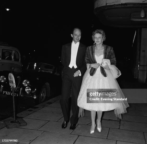 Colin Tennant, 3rd Baron Glenconner with his wife, Anne Tennant, Baroness Glenconner walking in a street at night, June 9th 1958.