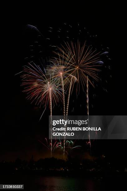 fireworks display at night, front view. colorful fireworks display on sky backgrounds and reflection on water of river. - firework display stock-fotos und bilder