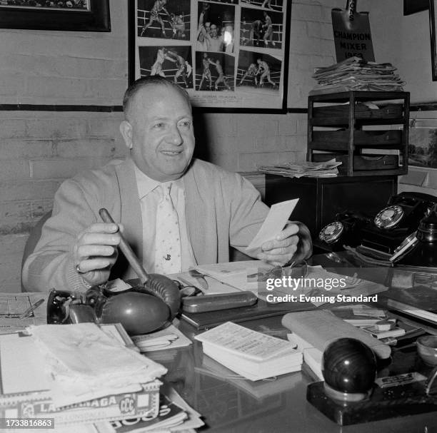 Boxing promotor Jack Solomons seated at a desk in his office, April 17th 1958.