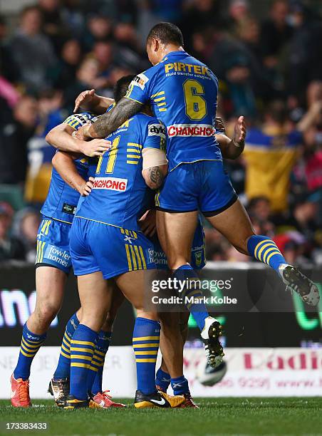 Luke Kelly of the Eels is congratulated by his team mates after scoring a try during the round 18 NRL match between Parramatta Eels and the Penrith...