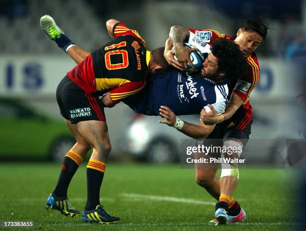 Rene Ranger of the Blues is dumped by Aaron Cruden and Tim Nanai-Williams of the Chiefs during the round 20 Super Rugby match between the Blues and...