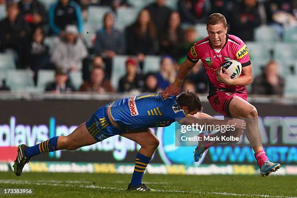 Matt Moylan of the Panthers beats a tackle during the round 18 NRL match between Parramatta Eels and the Penrith Panthers at Parramatta Stadium on...