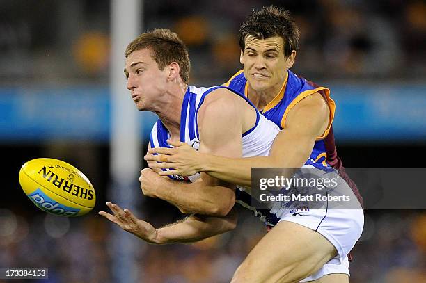 Shaun Atley of the Kangaroos handballs in the tackle during the round 16 AFL match between the Brisbane Lions and the North Melbourne Kangaroos at...