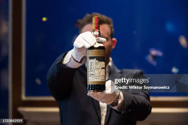 Sotheby's Global Head of Spirits, Jonny Fowle, poses with a bottle of Macallan 1926 Adami, the world's most valuable whisky , during a photocall at...
