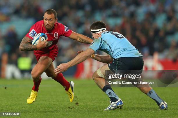 Quade Cooper of the Reds runs the ball during the round 20 Super Rugby match between the Waratahs and the Reds at ANZ Stadium on July 13, 2013 in...