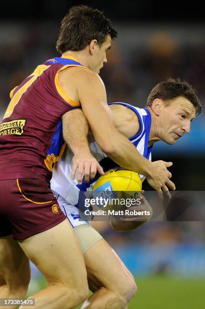 Brent Harvey of the Kangaroos is tackled during the round 16 AFL match between the Brisbane Lions and the North Melbourne Kangaroos at The Gabba on...